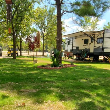 parked rv in grass with trees
